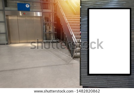 vertical blank showcase billboard or advertising light box for your text message or media content in front of elevator and stairs way in department store shopping mall, commercial, marketing concept