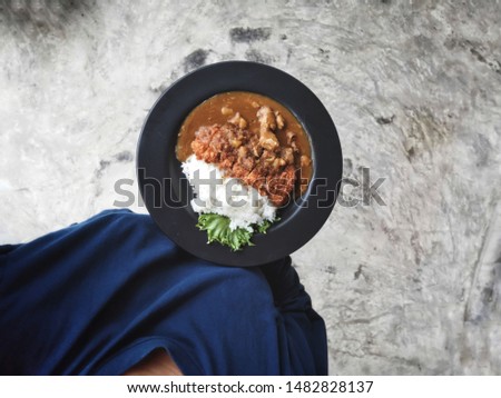 Selfie of curry rice and fried pork with hand