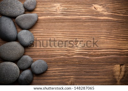 Balanced spa stones with camomile flower and wooden  background.