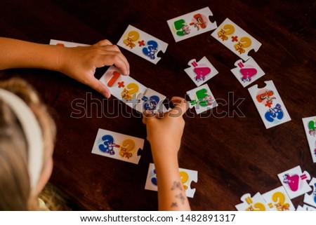 Kids are playing. Educational games. A child in kindergarten. The hands of a child. Maths. Cards for development.Stack of Math Flash Card.School cards with math problems