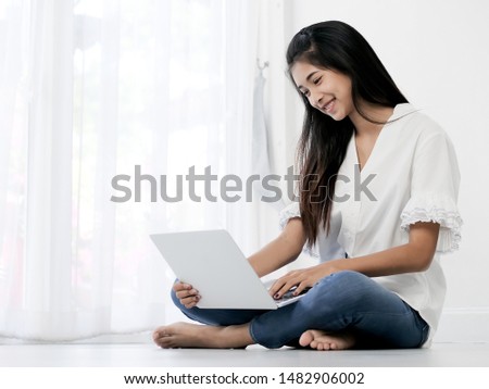 Happy Asian teen girl sitting on floor and using laptop at home, lifestyle concept.