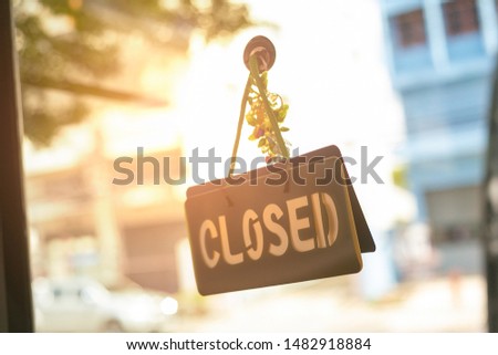 Closed sign hanging front of cafe with colorful bokeh light background. Business service