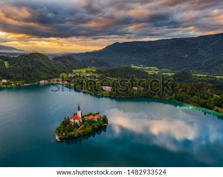 Bled, Slovenia - Beautiful aerial view of Lake Bled (Blejsko Jezero) with the Pilgrimage Church of the Assumption of Maria on a small island and dramatic reflecting clouds and sky at summer time