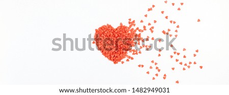 Valentine's Day. Creative holiday concept of love made from broken red heart shaped flying sweet confetti. Valentines day top view on white background.