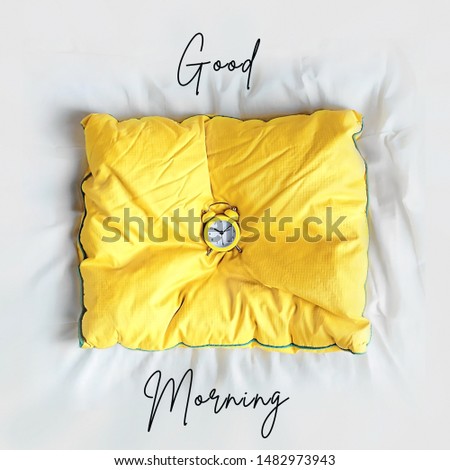 Good morning concept. alarm clock on yellow pillow on white background. alarm clock in bed.