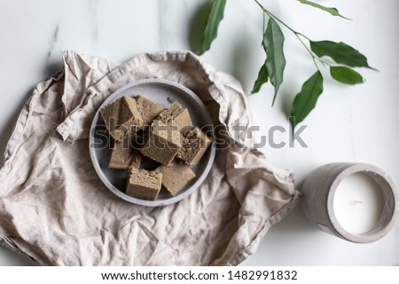 Portion of halva with vanilla and sunflower seeds on marble background with copy space