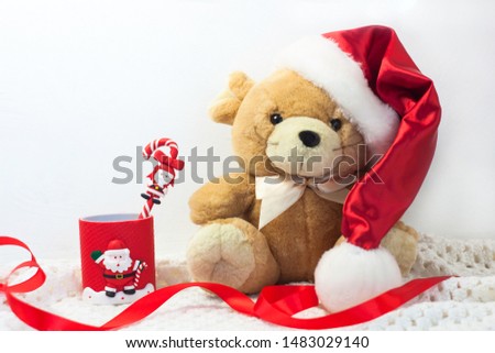 Christmas card with symbol of the year 2020 a rat in a red Santa hat and ribbon bow on a white background. Silver New Year decorations, soft toy, cute animals, copy space, front view.