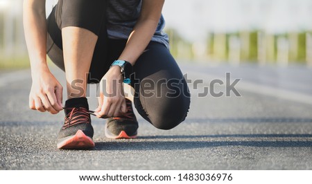 Running shoes runner woman tying laces for autumn run in forest park. Runner trying running shoes getting ready for run. Jogging girl exercise motivation heatlh and fitness. Royalty-Free Stock Photo #1483036976