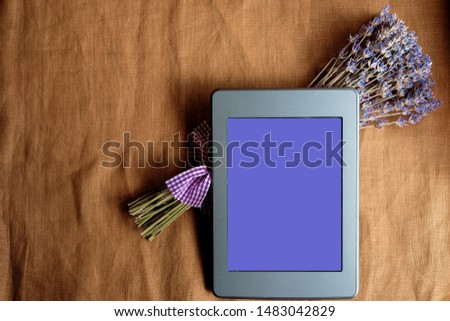 Mock up eBook and lavender bouquet on canvas tablecloth. Top view. Copy space.