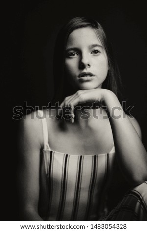 fashion picture of beautiful girl wearing black and white clothing. Studio picture, black background