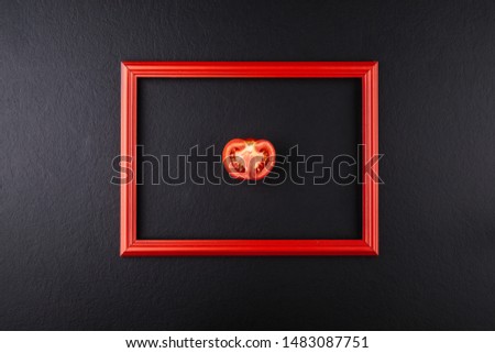 Tomato cut in half in red frame on black background 