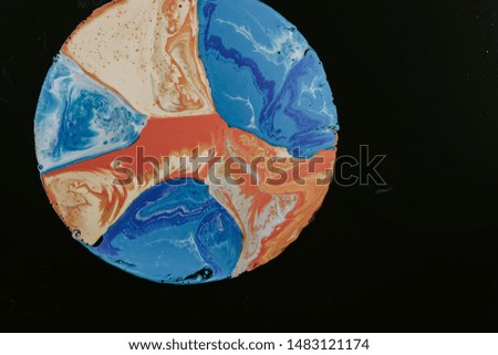 The Texture of circle is orange and light blue color on black background with the white lines sparkling on it