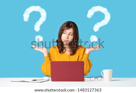 Young woman comparing with two things. Royalty-Free Stock Photo #1483127363
