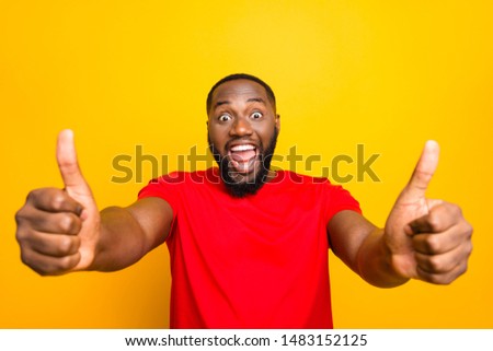 Photo of rejoicing ecstatic excited cheerful smiling man enjoying his purchase while isolated with yellow background