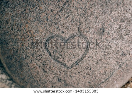 Heart sign carved on a stone. Sign of love on granite. Stone engraving