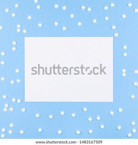 Creative Top view flat lay winter frame. Square Mockup pattern made of small white snowflakes letter envelope pastel blue background copy space minimalism Template design invitation cards
