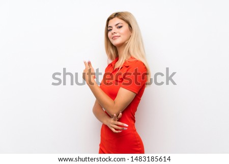 Teenager girl over isolated white background pointing back