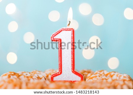 Candle number one on a blue background. Cake happy birthday candles. Bokeh. Royalty-Free Stock Photo #1483218143