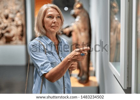 Mature woman in the historical museum looking at pictures