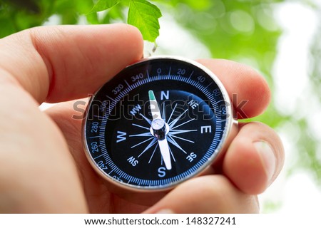 Hand holding silver black compass 