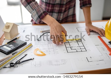 Female architect drawing blueprints in office workplace, one people alone.