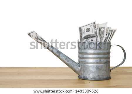 Rusty watering can filled with dollar bills. Background removed with clipping path