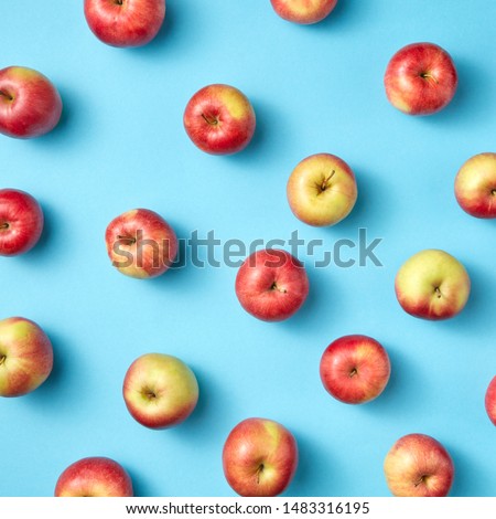 Fresh organic preshly picked apples as pattern on a blue background. Flat lay. Vegetarian eating concept.