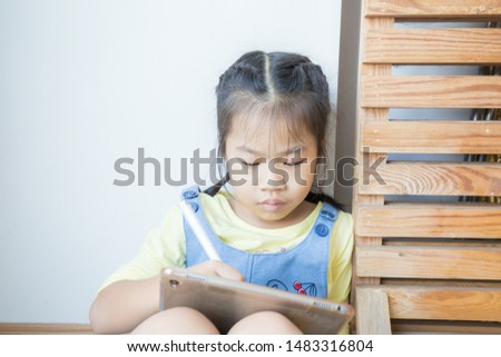 Asian school child girl drawing on tblet computer by hand education concept