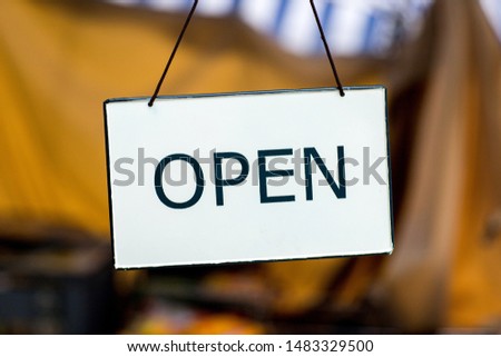 
A sign at the store that says the store is open.