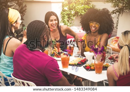 Group of friends enjoying meal and having fun outdoors - People talking and laughing togheter at the restaurant
