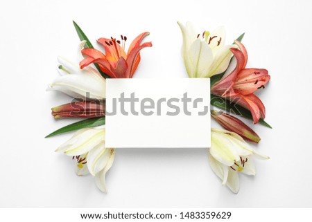 Blank card with fresh lily flowers on white background, top view. Space for text