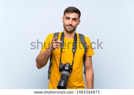 Young photographer man points finger at you