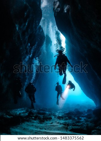 scuba divers exploring a cave