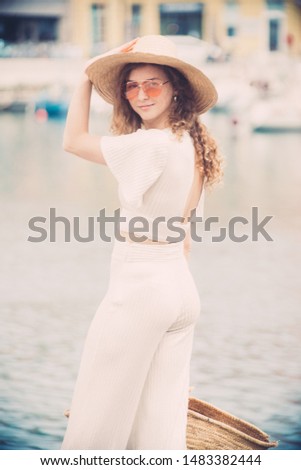 Millenial trendy Hipster teenager awaits to get on the yacht in an harbor's dock
