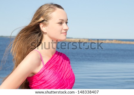 young beautiful slim woman in pink at the beach