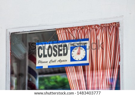 Closed "please call again" sign  at a barber shop