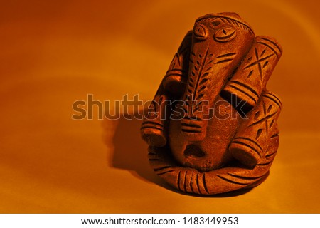 The picture depicts the Hindu God of knowledge and wit, Lord Ganesha. The surrounding yellow hallow is making the devotional background.