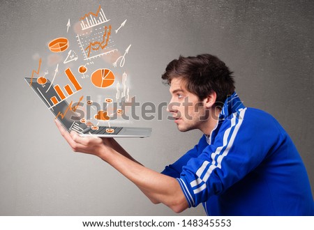 Handsome young man holding laptop with graphs and statistics