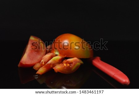 Fresh tomatoes sliced with a red knife - image