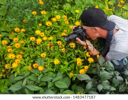 The photographer takes the camera flowers and insects. The guy with the camera in the flowers.