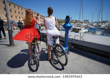 a couple of girls doing tourism by bike and taking pictures with the smartphone 