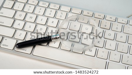 Magnifying glass tool on keyboard, online searching concept