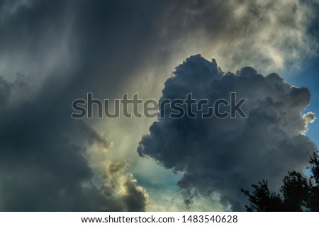Beautiful HDR sky with large puffy clouds and sunlight coming from behind cloud.