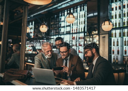 Team of colleagues socializing and working together at the bar