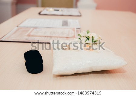 wedding rings on little decorated pillow in registry office. wedding moments background