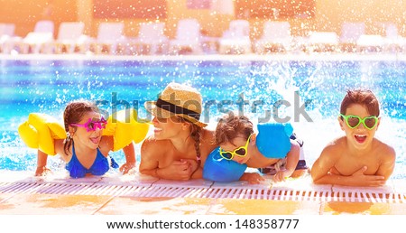 Happy family in the pool, having fun in the water, mother with three kids enjoying aqua park, beach resort, summer holidays, vacation concept  Royalty-Free Stock Photo #148358777