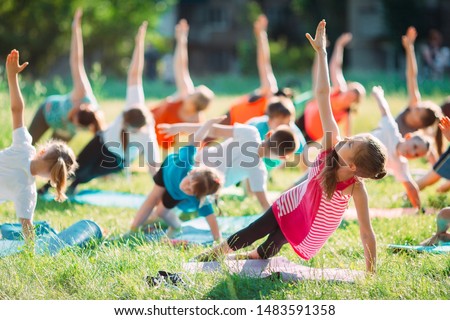 Yoga classes outside on the open air. Kids Yoga Royalty-Free Stock Photo #1483591358