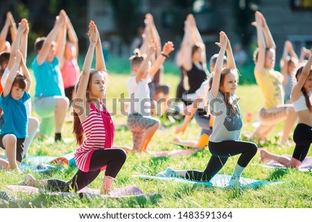 Yoga classes outside on the open air. Kids Yoga Royalty-Free Stock Photo #1483591364