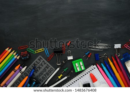 School supplies on a blackboard background with a copy space. Back to school concept.
