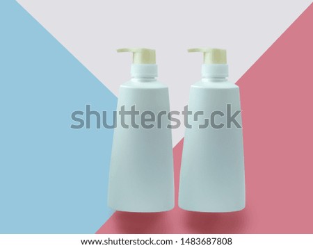 White cosmetic tubes on blue and pink background. Skin care, beauty concept.